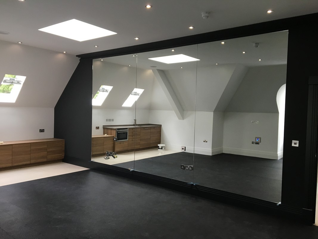 Frameless glass wall dividing loft conversion in Roehampton